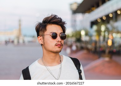 Portrait Of Young Handsome Chinese Man In Front Of Barcelona Port And Sea