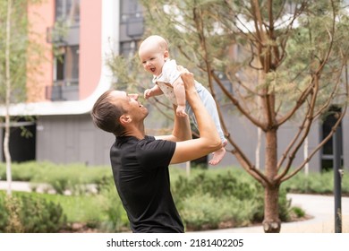 Portrait Of Young Handsome Father Holding His Adorable Cute Newborn Baby Boy. Lifestyle. Real People. Fatherhood And Parenthood Concept. Happy Father's Day.