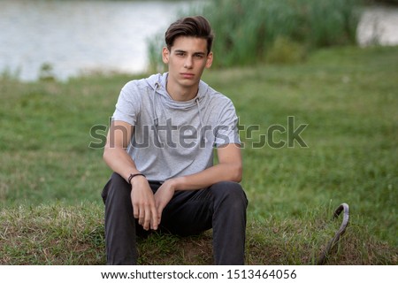 Similar – Stylish teenager sitting on a wooden bench on a city park