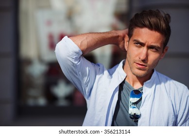 Portrait Of Young Handsome Man Touching His Hair And Looking Aside 
