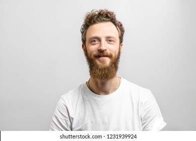 Portrait Of Young Handsome Softie, Good-looking Kind Hipster Man With Beard Smiling And Looking At Camera Over White Background.