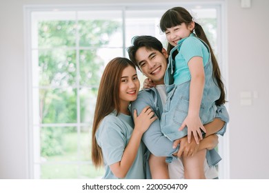 Portrait Of Young Happy Asian Family Spending Time Together At Living Room.