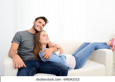portrait of a young happy cheerful love couple at home together in sofa 