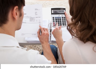 Portrait Of Young Happy Couple Calculating Budget