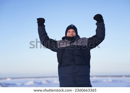 Portrait of young happy handsome man at winter snowy day smile and looking at camera 
