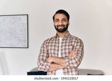 Portrait of young happy indian business man looking at camera standing with arms crossed at home office. Eastern confident male professional, smiling student, ethnic bearded entrepreneur, headshot.