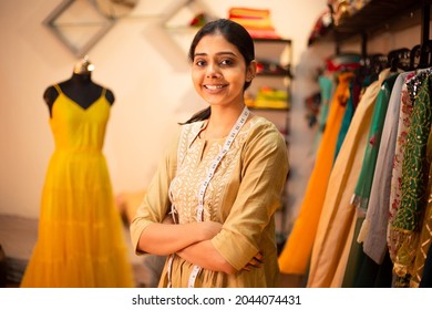 Portrait of Young happy indian woman, fashion designer tailor standing with crossed arms, measurement tape in garment workshop, seamstress, tailoring clothing on mannequin in  studio. skill india - Shutterstock ID 2044074431