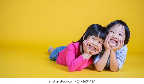 Portrait Of Young Happy Little Asian Boy Girl In On Yellow Background. Education For Preschool Toddler, Brother And Sister Lifestyle Back To School Children Together Concept Banner