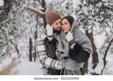 Portrait of a young happy and loving couple having fun in a snowy forest - Powered by Shutterstock