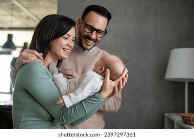 Portrait of young happy man and woman holding newborn cute baby. Happy family concept