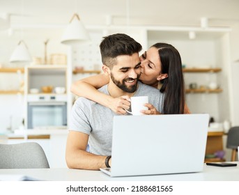 Portrait Of A Young Happy Smiling Couple Using Laptop Together At Home. Wireless Technology Computer Concept