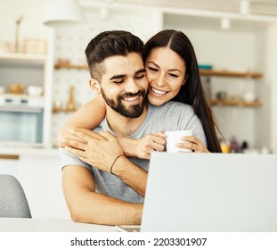 Portrait Of A Young Happy Smiling Couple Using Laptop Together At Home. Wireless Technology Computer Concept