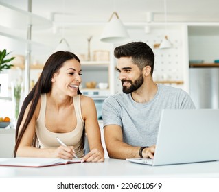 Portrait Of A Young Happy Smiling Couple Using Laptop Together At Home. Wireless Technology Computer Concept