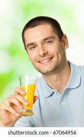 Portrait Of Young Happy Smiling Man Drinking Orange Juice, Outdoors