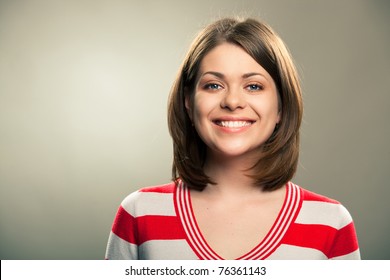 Portrait Of Young Happy Woman , Big Natural Smile, Beautiful Model Posing In Studio Over Gray Background . Isolated On Gray. Light Make-up Without Strong Retouching Natural Skin.