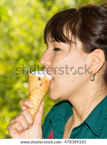 Portrait of young happy woman eating ice-cream, outdoor