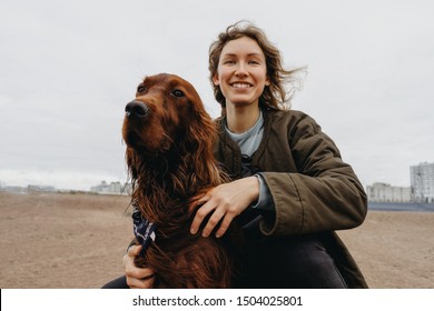 Portrait of a young happy woman with her dog. Irish setter dog and loving cheerful mistress. 