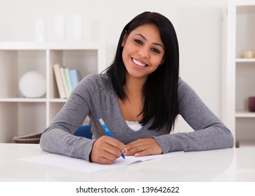 Portrait Of Young Happy Woman Writing On Paper