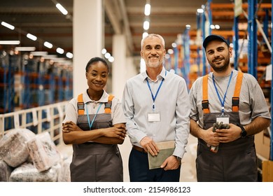 Portrait Of Young Happy Workers And Their Mature Foreman At Distribution Warehouse Looking At Camera.