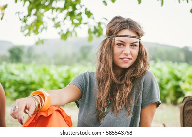 Portrait Of Young Hippie Girl With Long Hair And Headband Looking At Camera