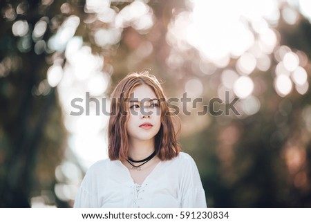 Portrait of young hipster Asian girl  posing in the autume park forest bokeh background