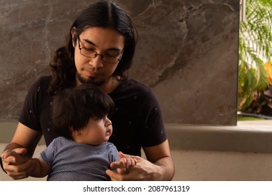 Portrait Of A Young Hispanic Dad And His Baby Playing