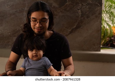 Portrait Of A Young Hispanic Dad And His Baby Playing