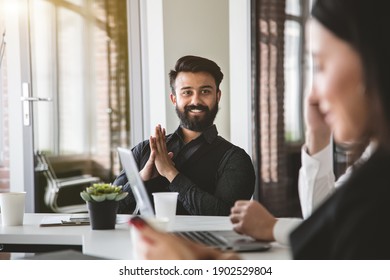 Portrait Of Young Indian Businessman In A Business Suit Sitting At A Table In A Meeting