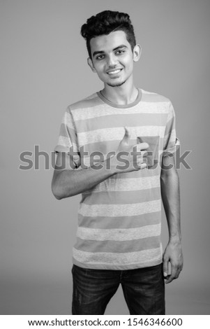 Similar – Portrait of a smiling Caucasian man in his 20s wearing a sweatshirt against a dark background.