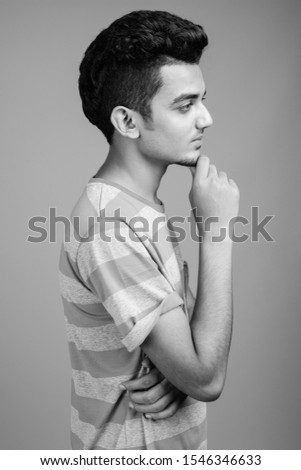 Similar – Boy with a white T-shirt in front of a dark wall