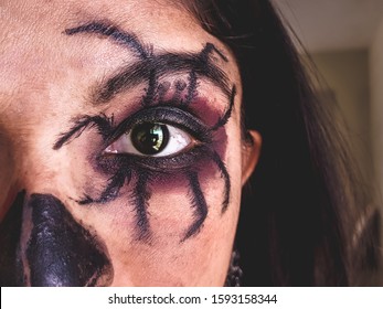 Portrait of young Indian woman with scared Halloween makeup on eye.