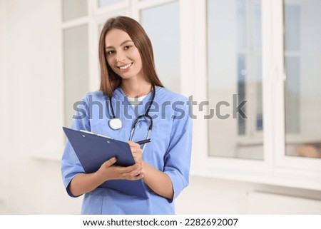 Portrait of young intern wearing uniform in university hall, space for text