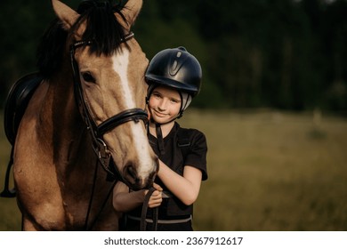 Portrait of a young jockey with a horse, horse riding training, a boy stroking a horse, a lesson for a young jockey in an equestrian school or club, pet - Powered by Shutterstock