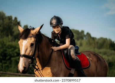 Portrait of a young jockey with a horse, horse riding training, a boy stroking a horse, a lesson for a young jockey in an equestrian school or club, pet - Powered by Shutterstock