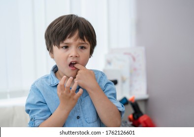 Portrait Young Kid Putting Finger In His Mouth Feeling Hurt From Falling First Tooth,Emotional Child Boy Standing Alone With Thinking Face Or Nervous, Health Care Or Mental Health 