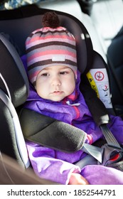 Portrait Of Young Kid Wearing Winter Clothing Sitting In Baby Car Seat With Adjustable Headrest