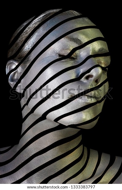 Portrait of a young lady\
with creative makeup. Conceptual idea of bold body art painting\
isolated on black background. Abstract picture of diagonal lines on\
woman face.