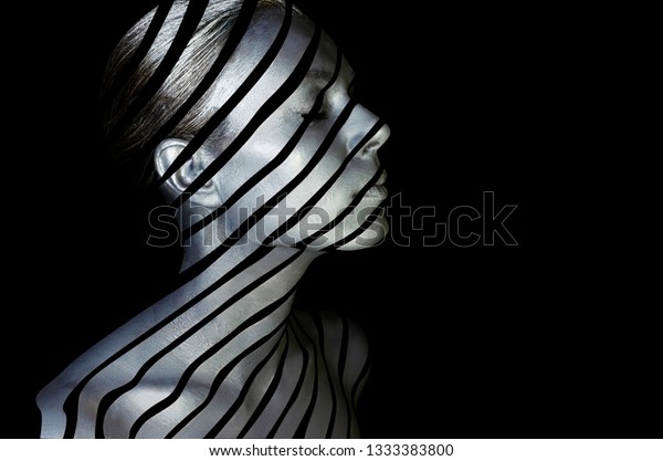 Portrait of a young lady\
with creative makeup. Conceptual idea of bold body art painting\
isolated on black background. Abstract picture of diagonal lines on\
woman face.