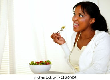 Portrait Of A Young Lady Looking To Her Right While Eating A Vegetarian Salad On A Light Background. With Copyspace.