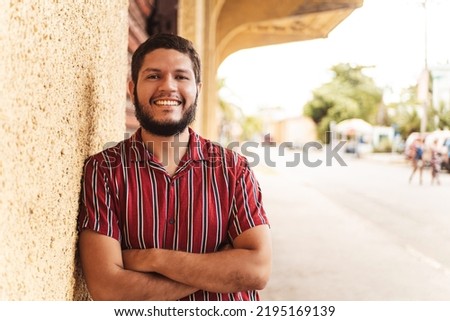 portrait of a young latin american man smiling looking at camera.