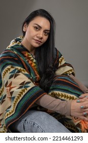 Portrait Of Young Latin Woman With Cheerful Black Hair, Natural Beauty And Fashion With Poncho Of Latin American Culture, Colorful Clothes And For The Cold