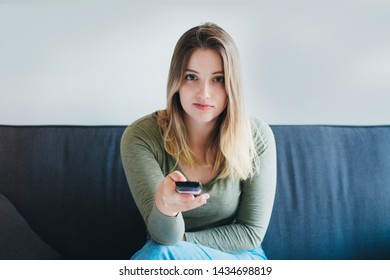 Portrait of young latin woman sitting on sofa watching tv. Television concept - Shutterstock ID 1434698819