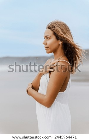 portrait of young latina woman looking towards the sea on the beach. Concept of life changes, self-care and serenity.