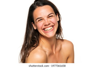 Portrait of a young laughing woman without makeup on a white background