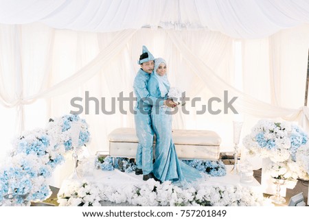 Portrait of young lovely couple hugging and holding hand on bridal dais. 