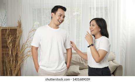 A Portrait Of A Young Malay Asian Couple Talking To One Another Fondly During The Day. They Are Both Laughing Naturally As They Share A Joke Together. 