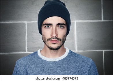 Portrait Of A Young Male Adult Looking At The Camera Wearing A Toboggan Hat And Blue T-shirt.
