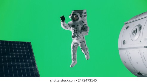 Portrait of a Young Male Astronaut Posing in a Space Suit on an Isolated Green Screen Background Together with a Mock Up Spaceship, Satellite or a Space Station with Modern Solar Panels - Powered by Shutterstock