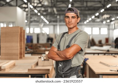 Portrait of young male carpenter standing in the wood workshop - Powered by Shutterstock