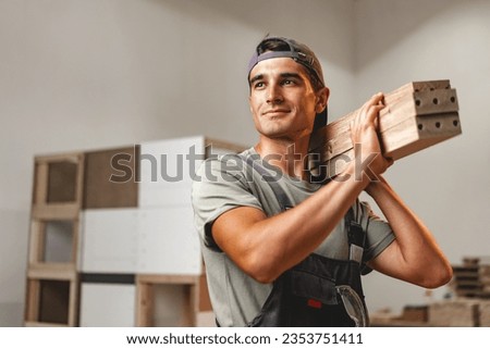 Portrait of young male carpenter standing in the wood workshop